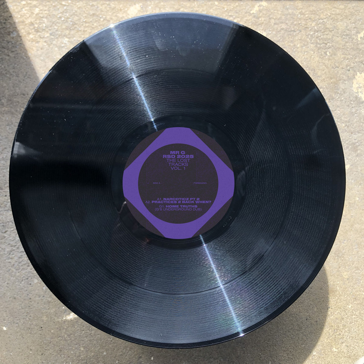 Vista del vinilo Mr. G – RSD 2025 The Lost Tracks Vol. 1 mostrando el lado A con pistas visibles, arte púrpura y créditos impresos.