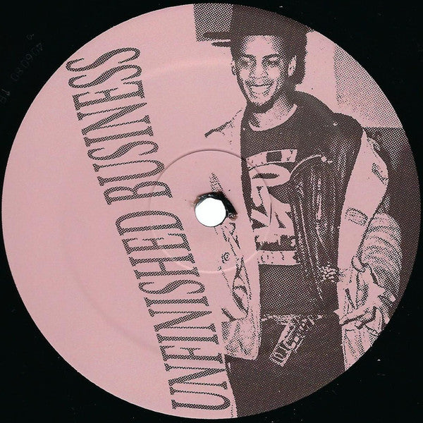 Portada trasera del vinilo 12" EP Nature Boy – Unfinished Business, editado por Nature Boy. Texto impreso: título del disco en vertical junto a una foto en blanco y negro del artista.