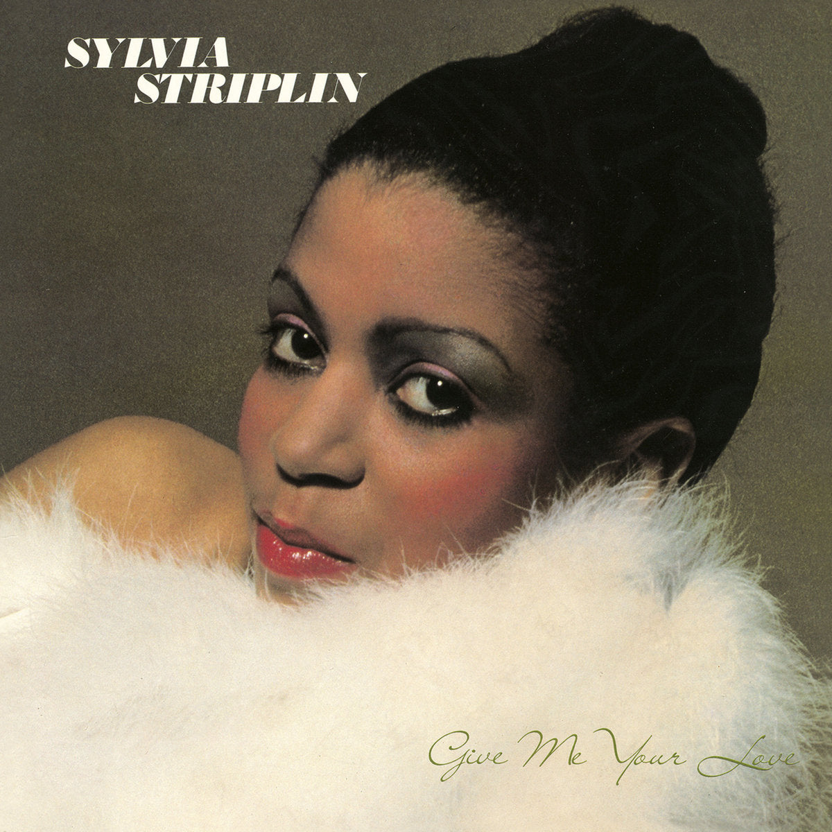 Portada del vinilo Sylvia Striplin – Give Me Your Love, retrato de la cantante entre plumas blancas sobre fondo oscuro.