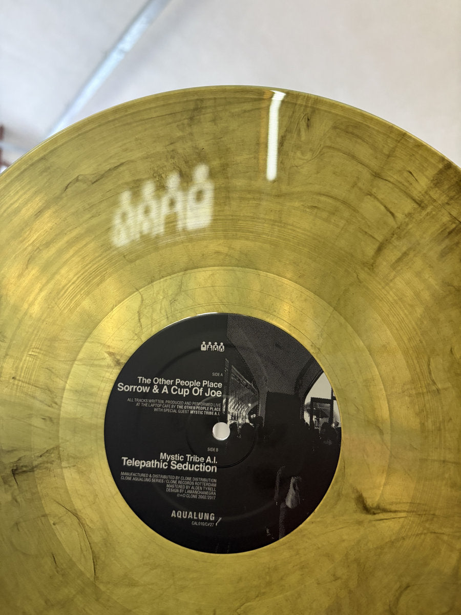 Vinilo en mármol café/negro con arte visible y créditos detallados del disco The Other People Place – Sunday Night Live At The Laptop Cafe bajo Clone Aqualung Series. Texto impreso: lista de temas y sello Aqualung.