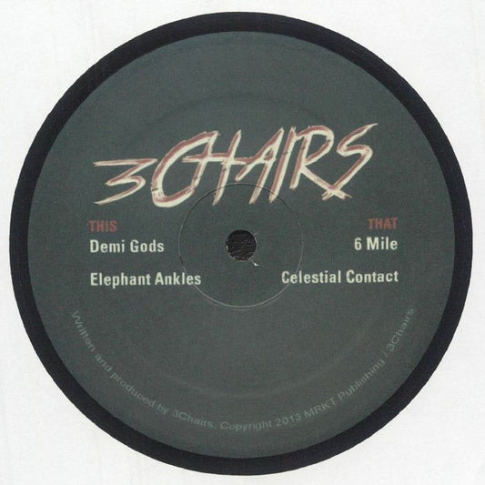 Etiqueta central del lado A del vinilo 3Chairs – Demigods, con el logo de 3Chairs, lista de temas “Demi Gods”, “Elephant Ankles”, “6 Mile” y “Celestial Contact”, créditos de producción y diseño sobrio del sello Three Chairs en formato 12" reimpresión.