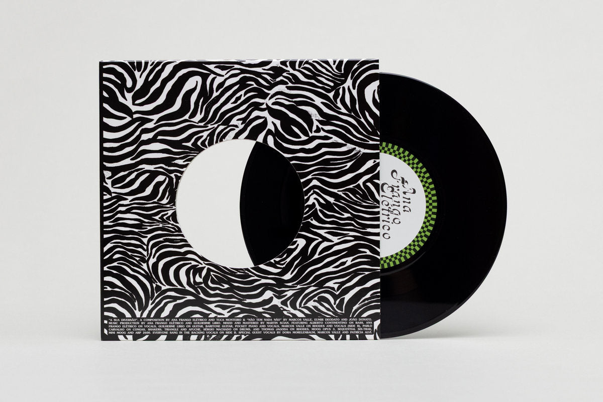 Lado A del vinilo 7" Ana Frango Elétrico – A Sua Diversão / Não Tem Nada Não en Mr Bongo, disco negro parcialmente fuera de la funda con label verde A Sua Diversão visible.