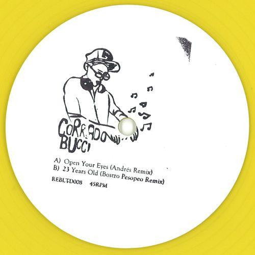Etiqueta central del vinilo Corrado Bucci – Open Your Eyes de Rebirth, edición limitada 10" amarilla, con arte dibujado del DJ, pistas “Open Your Eyes (Andrés Remix)” y “23 Years Old (Bostro Pesopeo Remix)” claramente visibles en la cara A.