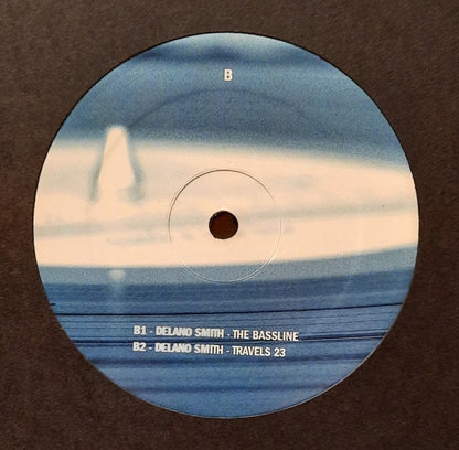 Etiqueta del lado B del vinilo Delano Smith / Norm Talley – Straight Up No Chaser en tonos azulados mostrando B1 The Bassline y B2 Travels 23 sobre fondo difuminado