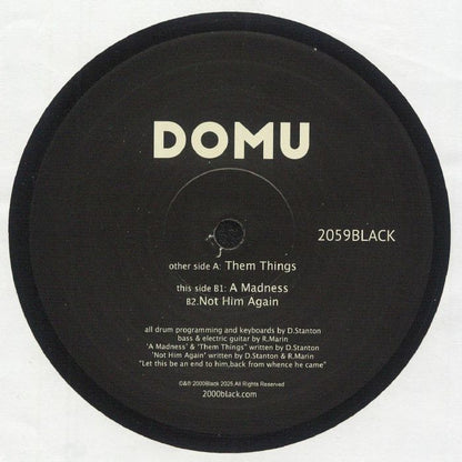 Etiqueta central lado B del vinilo Domu – Them Things en 12" de 2000 Black, con créditos, pistas “A Madness” y “Not Him Again”, y número de catálogo 2059BLACK.