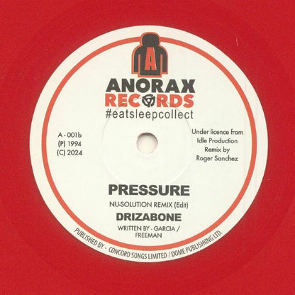 Etiqueta central del lado B del vinilo rojo Drizabone – Pressure en sello Anorax, con la versión “Pressure (Nu-Solution Remix Edit)” remezclada por Roger Sanchez; se aprecian créditos, catálogo A-001b y estilo clásico de reedición 7" sencillo.