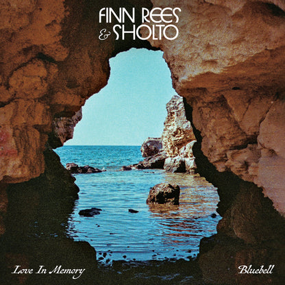 Portada del vinilo Finn Rees & Sholto – Love In Memory / Bluebell editado por Mr Bongo, mostrando una vista marítima a través de una cueva rocosa con tonos cálidos y el logo del disco centrado arriba.