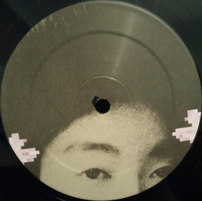 Etiqueta ilustrada del vinilo Japanese Telecom – Virtual Geisha mostrando detalle del rostro en tonos grises sin información textual.