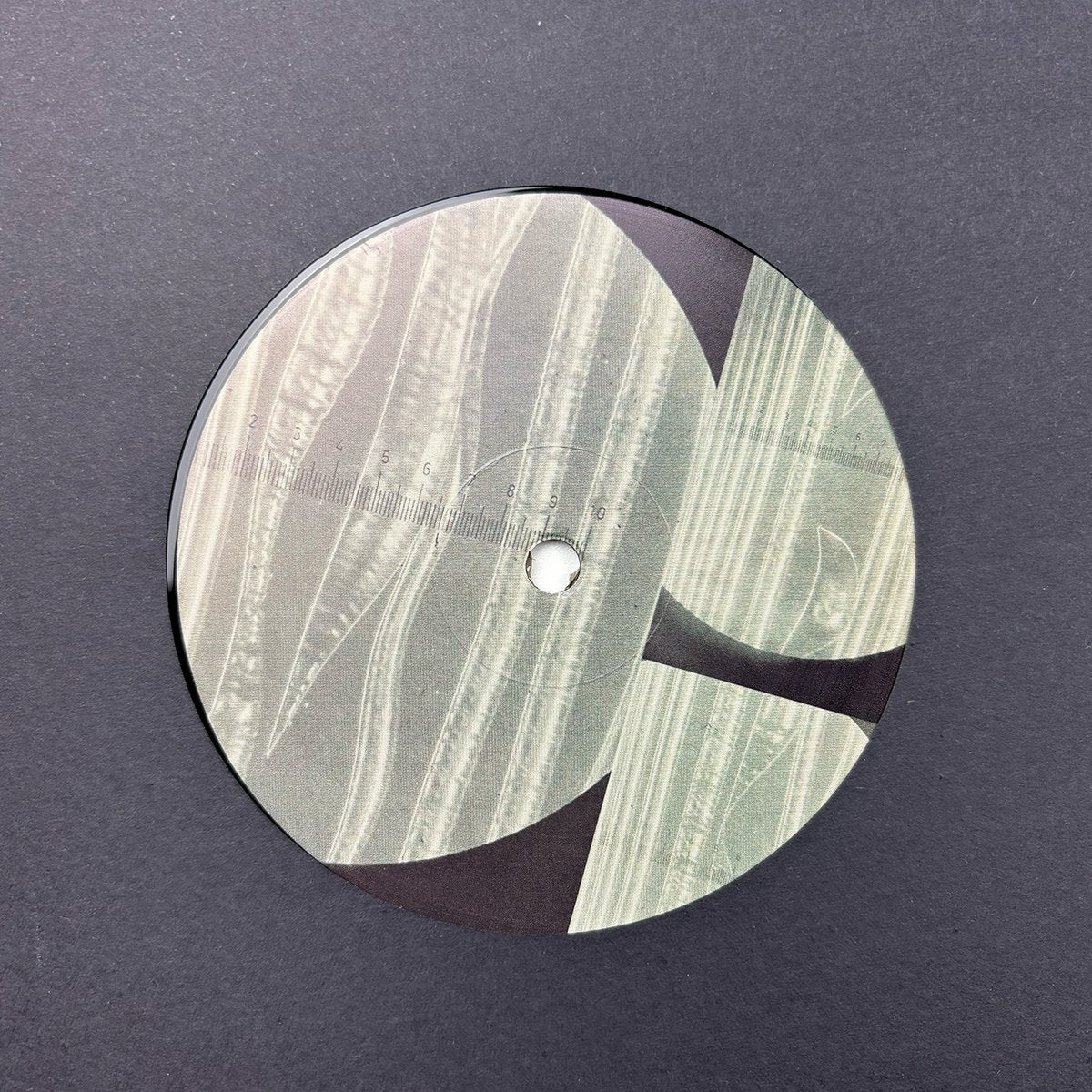 Lado B de vinilo Jimpster – Bassic Rollers EP con etiqueta ilustrada abstracta en tonos grises sin texto visible.
