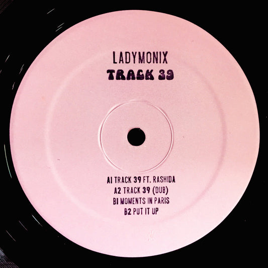 Portada delantera del vinilo LADYMONIX - "Track 39" publicado por Frizner Electric en formato 12". Diseño minimalista con fondo rosa y tipografía negra. Tracklist impreso con los temas del disco.
