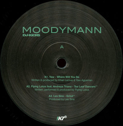 Etiqueta central del lado A del vinilo Moodymann – DJ-Kicks con temas de Yaw, Flying Lotus y Les Sins sobre diseño negro con logo !K7.