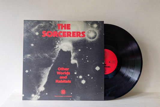 Vinilo The Sorcerers – Other Worlds And Habitats de ATA Records en formato LP, mostrando la portada y el disco negro con etiqueta roja parcialmente visible.
