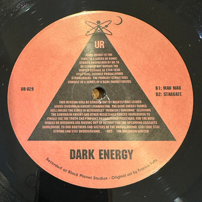 Lado B del vinilo UR – Dark Energy, etiqueta naranja con pistas B1/B2, catálogo UR-029 y texto de misión.