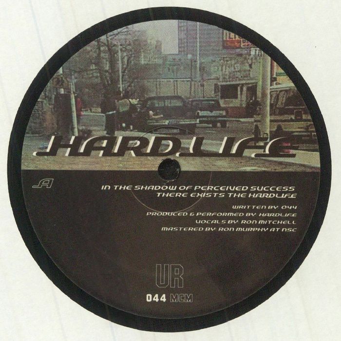 Lado A del vinilo UR – Hardlife, reedición 12" de Underground Resistance con arte urbano, cita impresa, créditos y catálogo 044 MCM en etiqueta central.