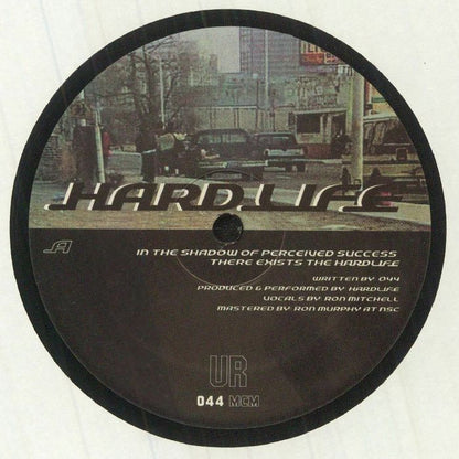 Lado A del vinilo UR – Hardlife, reedición 12" de Underground Resistance con arte urbano, cita impresa, créditos y catálogo 044 MCM en etiqueta central.